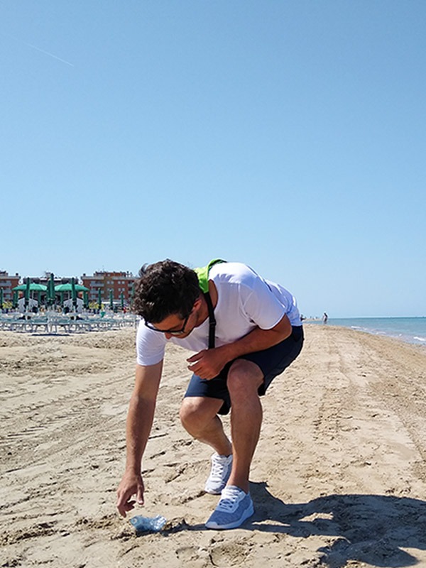 Immagine raccolta plastica in spiaggia con zaino plogging